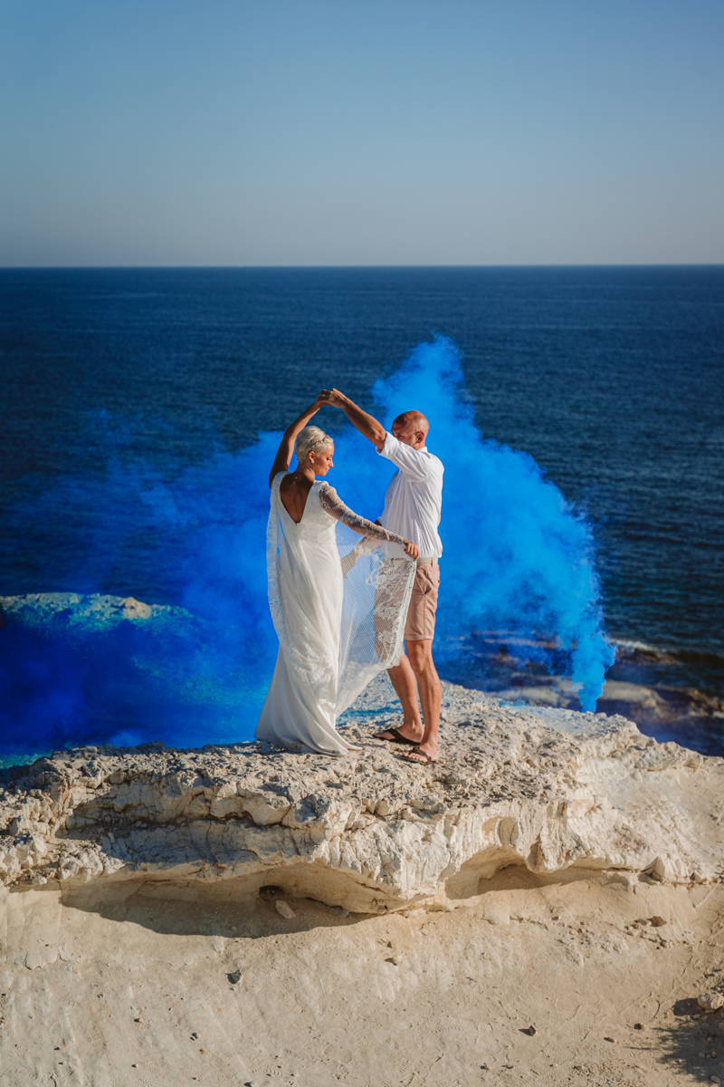 Blue flare adds drama to the couple's first dance on the rocks in Cyprus