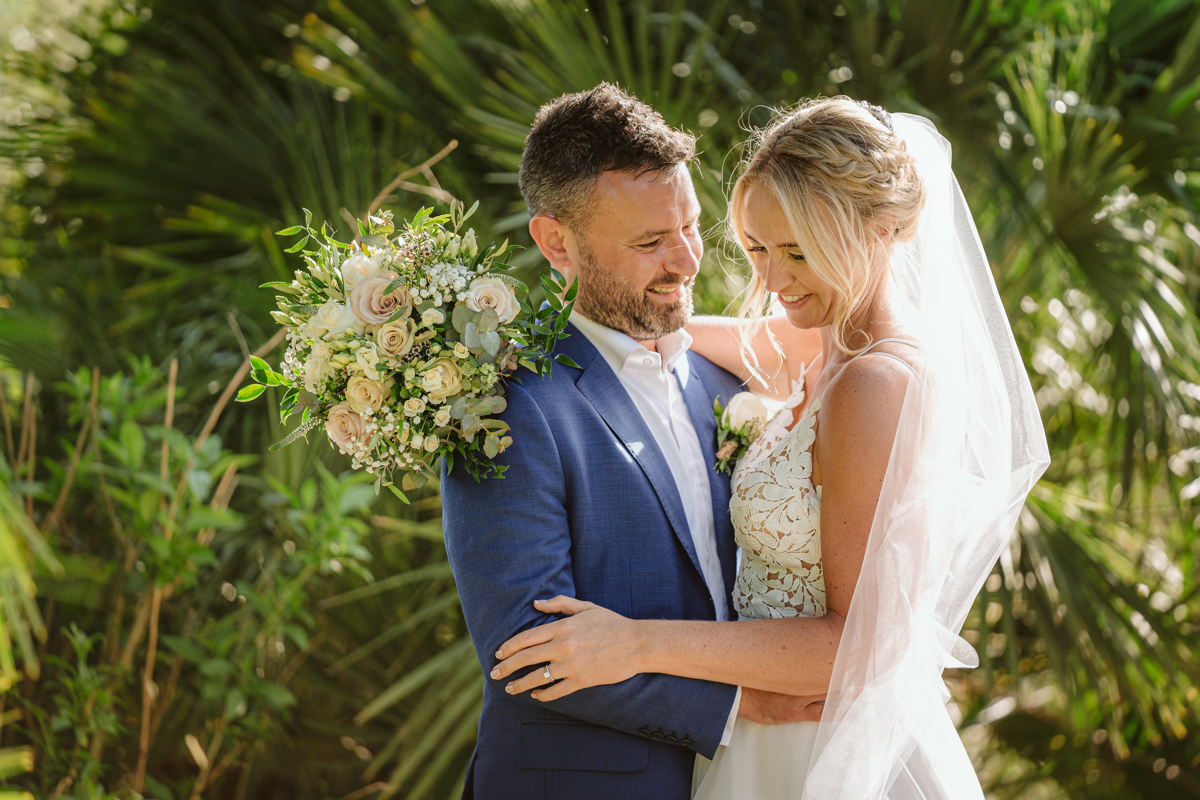 Can Gall Ibiza wedding photographer takes picture of couple embracing with bouquet