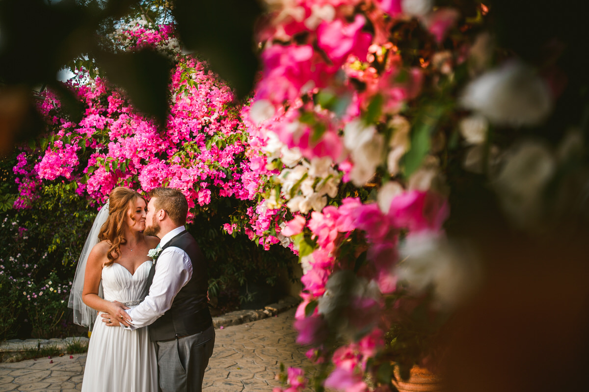 Newly weds kissing by blossom Vasilias Cyprus
